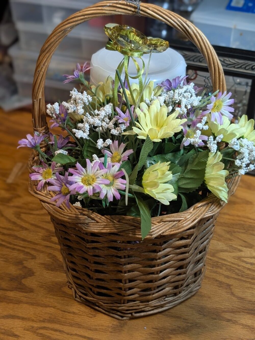 Small wicker basket with flowers and butterfly